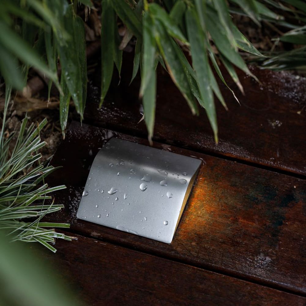 Lombardo Tegolo una lampada segnapasso poggiata su un pavimento in prossimità di un vialetto